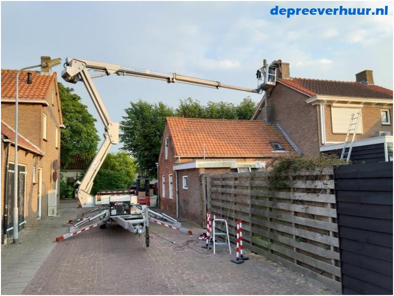 Werkzaamheden aan schoorsteen met hoogwerker